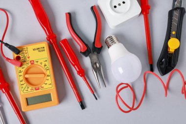 Different electrical tools on grey background, flat lay