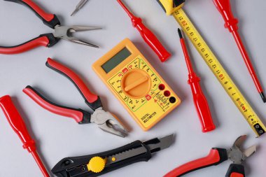 Different electrical tools on grey background, flat lay