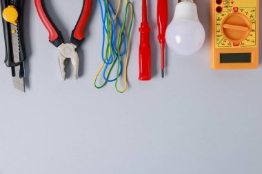 Gri arka planda, düz zeminde farklı elektrikli aletler var. Metin için boşluk