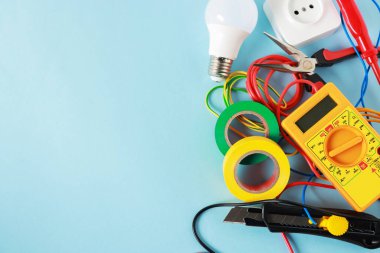 Açık mavi arka planda, düz zeminde farklı elektrikli aletler. Metin için boşluk
