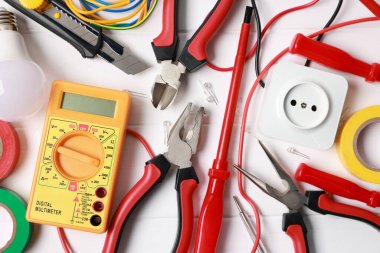Different electrical tools on white wooden table, flat lay