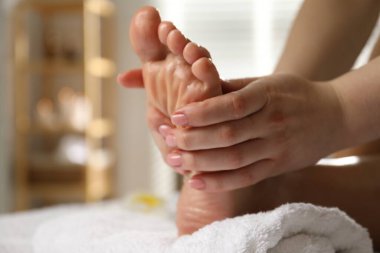 Kaplıca salonunda ayak masajı yaptıran bir kadın, yakın plan. Metin için boşluk