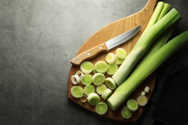 Chopped leeks and knife on grey table, top view. Space for text