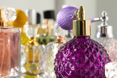 Aydınlık arka planda şişelerde farklı aromatik parfümler, yakın plan.