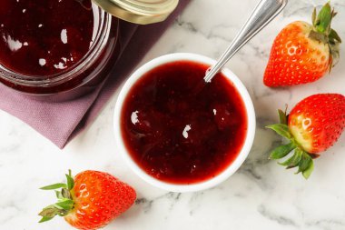 Delicious strawberry sauce and fresh berries on white marble table, flat lay