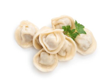 Delicious boiled dumplings (pelmeni) with fresh parsley isolated on white, top view