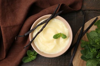 Tasty vanilla pudding, mint and pods on wooden table, flat lay