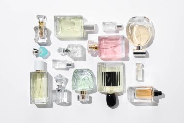 Farklı aromatik parfümler beyaz arka planda şişelerde, düz yerde