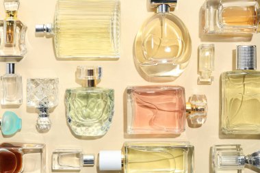 Bej arka planda çeşitli parfüm şişeleri, düzlük