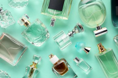 Turkuaz arka planda çeşitli parfüm şişeleri, düzlük
