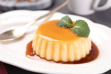 Karamel soslu lezzetli puding ve nane şekeri, yakın plan.