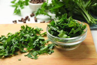 Fresh parsley in bowl on white table, closeup