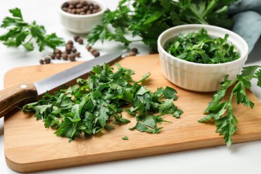 Fresh parsley, knife and pepper on white table, closeup