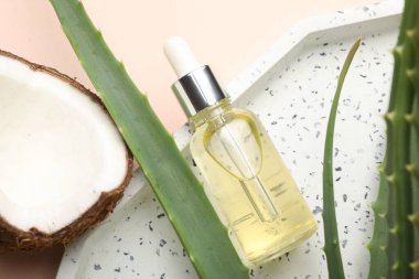 Saç tedavisi. Kozmetik ürün, hindistan cevizi ve aloe yaprakları bej arka planda, düz yatar