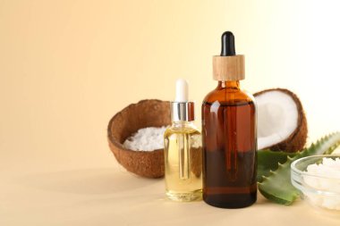 Saç tedavisi. Kozmetik ürünler, hindistan cevizi, tereyağı talaşı ve bej arka planda aloe yaprakları. Metin için boşluk