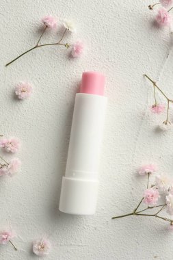 Nemlendirici dudak kremi ve jigolo çiçekleri açık desenli masa, düz yatıyordu.