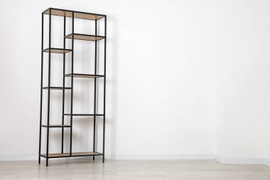 Empty shelving unit near white wall indoors, space for text