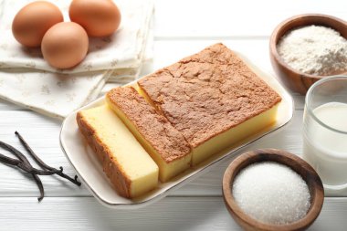 Tasty Japanese Castella sponge cake and ingredients on white wooden table