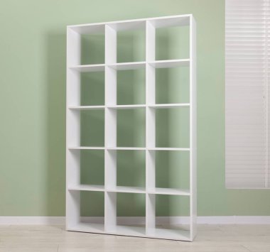 Empty shelving unit near olive wall indoors
