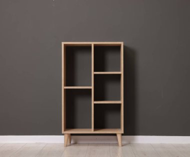 Empty shelving unit near grey wall indoors