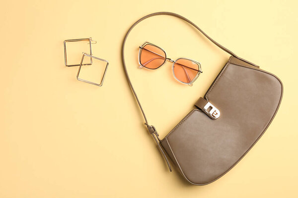 Beautiful bag and stylish accessories on beige background, flat lay. Space for text