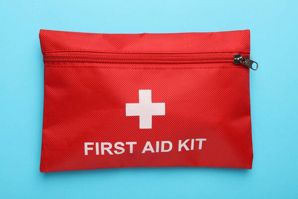 Комплект первой помощи на светло-голубом фоне, вид сверху