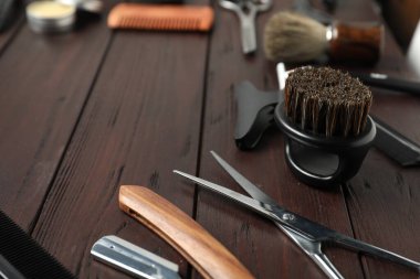 Many different barber's tools on wooden table, closeup. Space for text