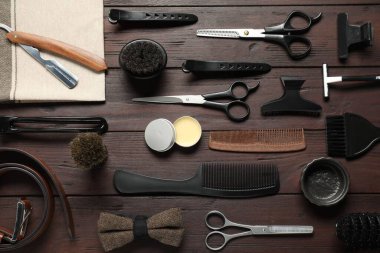 Birçok farklı berber aletleri ahşap masada, düz yatıyordu.