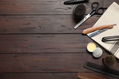 Many different barber's tools on wooden table, flat lay. Space for text