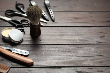Many different barber's tools on wooden table, closeup. Space for text