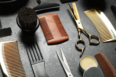 Many different barber's tools on black textured table, closeup