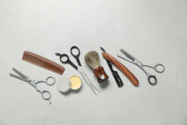 Many different barber's tools on light grey background, flat lay
