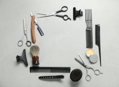Frame made of many different barber's tools on light grey background, flat lay. Space for text