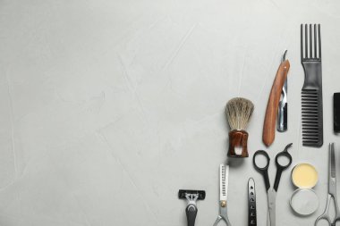 Many different barber's tools on light grey table, flat lay. Space for text