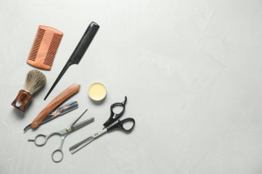 Many different barber's tools on light grey table, flat lay. Space for text
