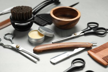 Açık gri masada birçok farklı berber aleti var, yakın plan.