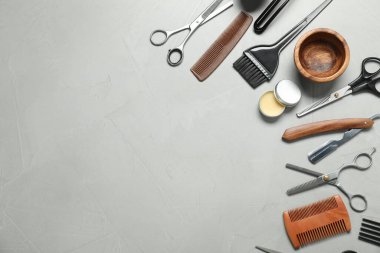 Many different barber's tools on light grey table, flat lay. Space for text