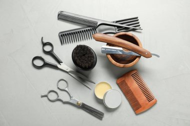 Many different barber's tools on light grey background, flat lay