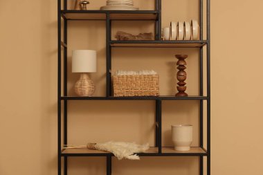 Shelving unit with decor near beige wall indoors