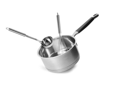 Saucepan, ladle and whisk in air on white background