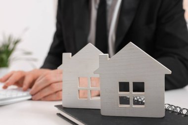 Ofisinde hesap makinesi olan bir emlakçı, ev rakamlarına ve not defterine odaklan. Ev Değerlendirmesi