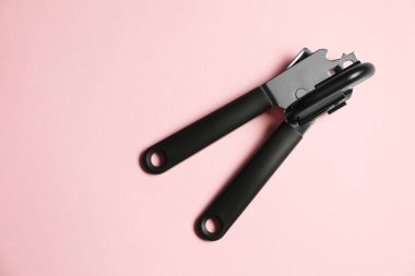 Pembe arka planda bir konserve açacağı, üst manzara. Metin için boşluk