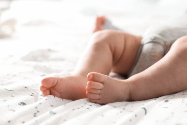 Küçük bebek yatakta uzanıyor, yakın plan.