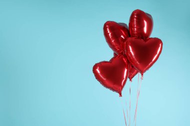 Açık mavi arka planda bir sürü kırmızı kalp şeklinde balon, yazı için boşluk. Sevgililer Günün kutlu olsun.