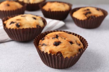 Açık gri masada çikolata parçalı lezzetli kek, yakın plan.