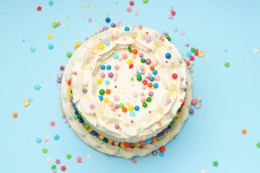 Nefis bento keki, açık mavi masa üzerine renkli serpiştirilmiş, üst manzara.