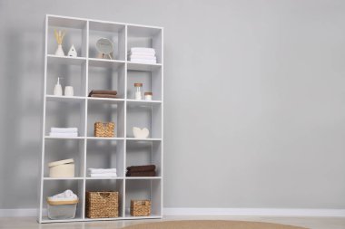 Açık gri duvarın yanında dekorlu raf ünitesi. Metin için boşluk