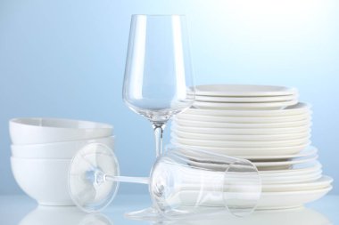 Different clean dishware on light blue background