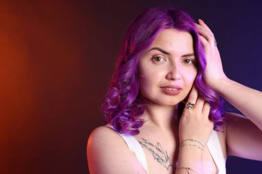 Parlak mor saçlı ve Latince dövmeli güzel bir kadın. Metin için boşluk