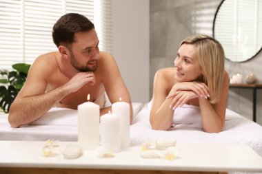 Spa salonundaki masaj masalarında yatan mutlu çift